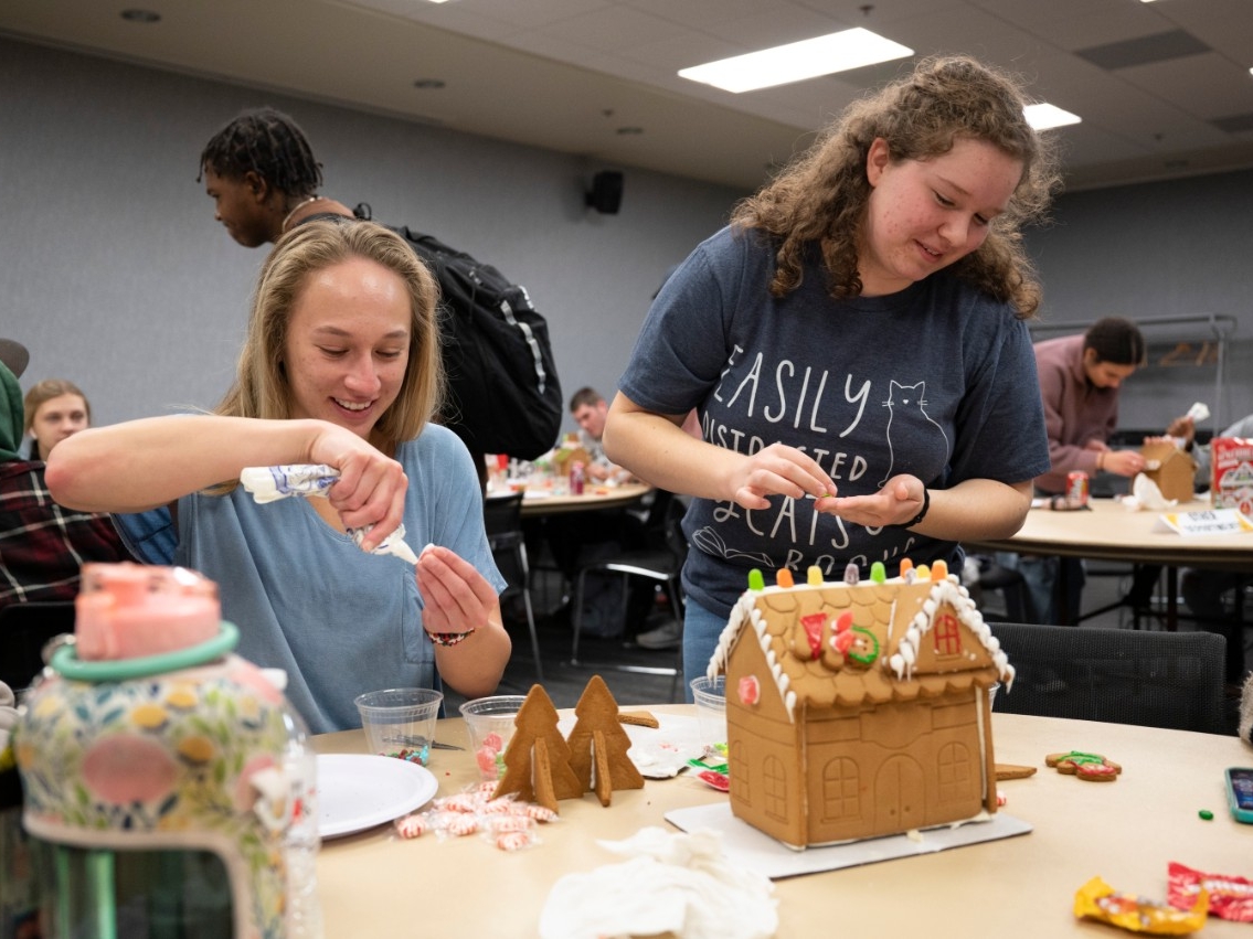 NKU STEM students having fun and being creative as they decorate gingerbread houses at the STEM Pizza Lunch.