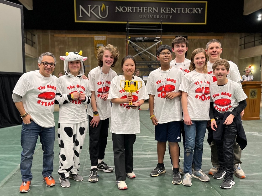 A middle school robotics excitedly poses for a picture with their trophy at the annual Kentucky FIRST LEGO League Championship Tournament at Northern Kentucky University.