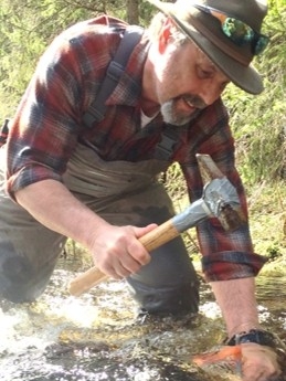 Dr. Durtsche hammering a rock in a creek.