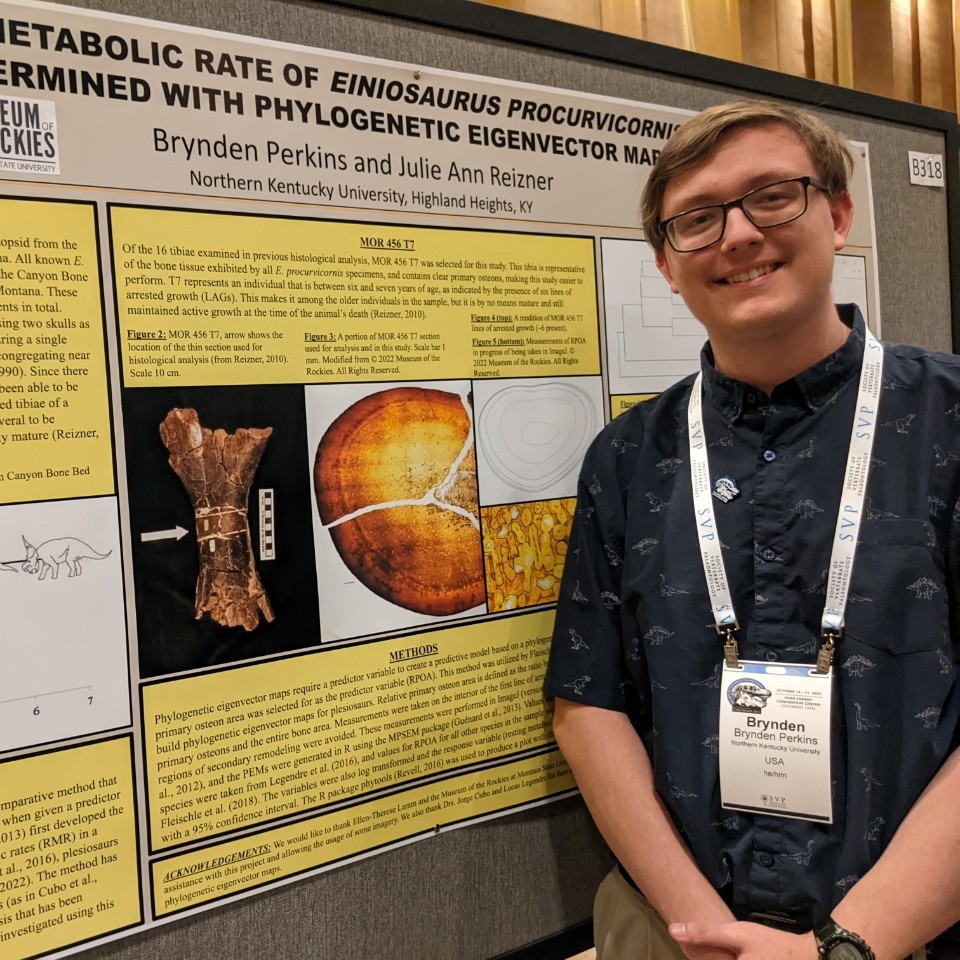 Brynden Perkins smiles next to his research poster.