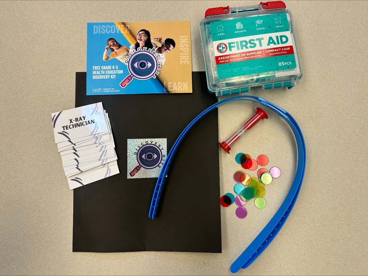 Flat lay of ER discovery kit featuring a first aid kit and headbands activity.