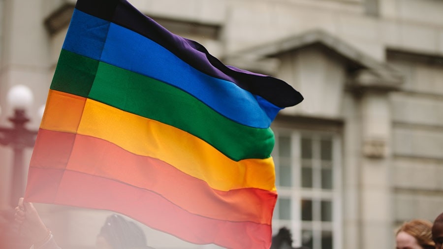 Pride parade with rainbow flag in the city