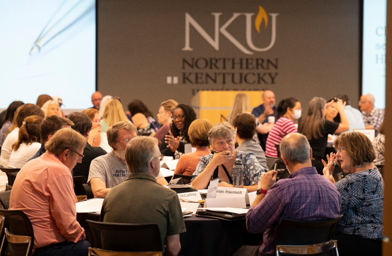 Faculty seated at tables during institute